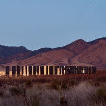 Los Milics Vineyard tasting room buiding in middle of desert, lit up at night